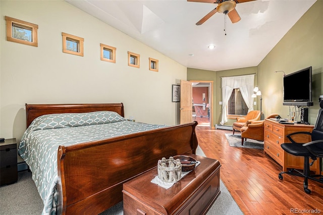 bedroom featuring baseboard heating, ceiling fan, vaulted ceiling, and light hardwood / wood-style flooring