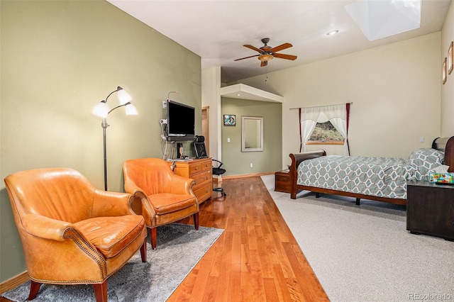 bedroom featuring hardwood / wood-style floors, ceiling fan, and a skylight