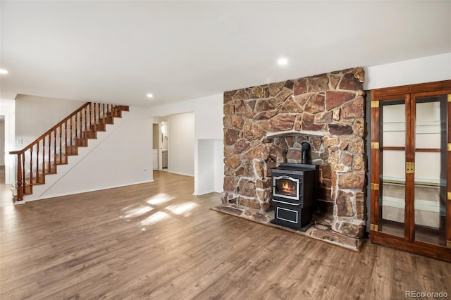 unfurnished living room with a wood stove and hardwood / wood-style flooring