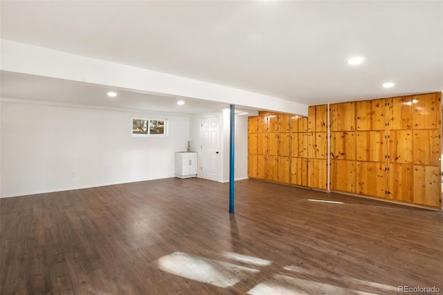 basement with wooden walls and dark hardwood / wood-style floors