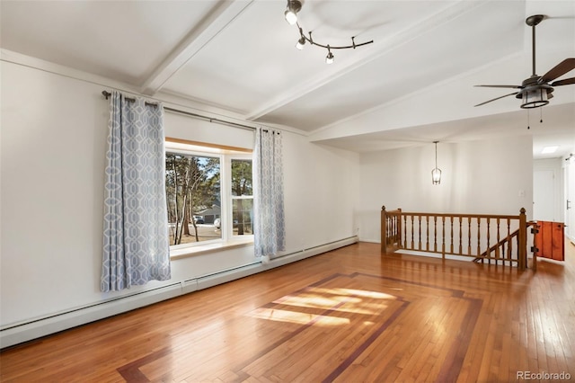 empty room featuring vaulted ceiling with beams, ceiling fan, baseboard heating, and hardwood / wood-style flooring