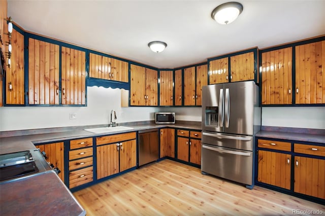 kitchen with light wood-type flooring, sink, and appliances with stainless steel finishes