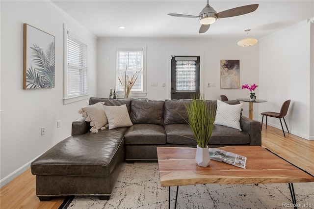 living room with baseboards, wood finished floors, and ornamental molding