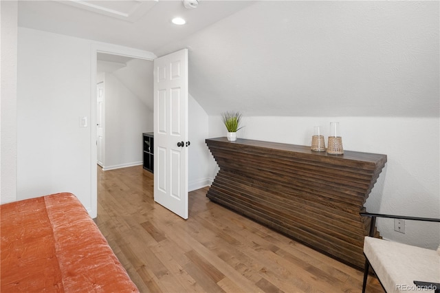 interior space with recessed lighting, baseboards, light wood-style flooring, and vaulted ceiling