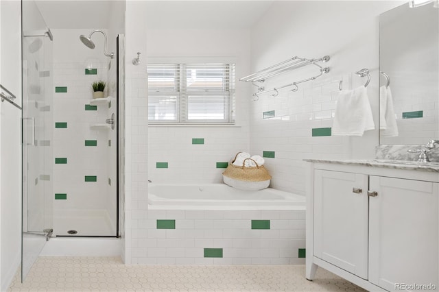 full bath featuring vanity, a shower stall, a garden tub, and tile patterned flooring