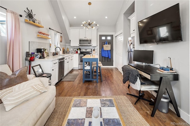 interior space featuring a notable chandelier, lofted ceiling, dark wood-style floors, recessed lighting, and baseboards