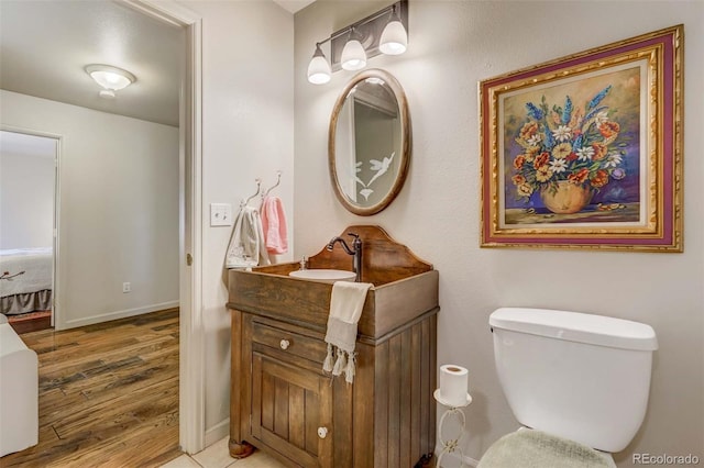 bathroom with vanity, hardwood / wood-style flooring, and toilet