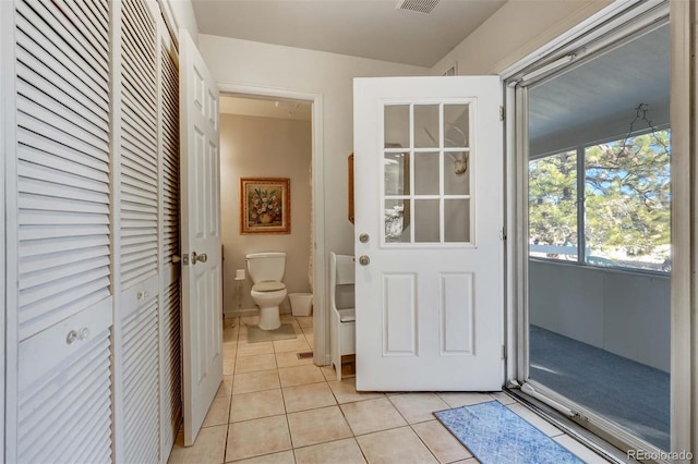 interior space featuring toilet and tile patterned flooring