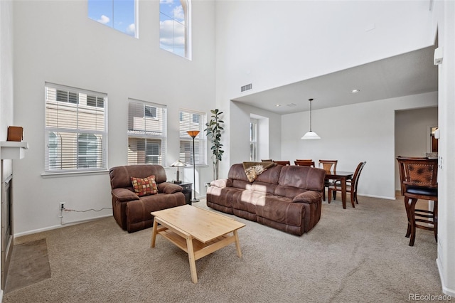 living area with visible vents, a fireplace with flush hearth, recessed lighting, carpet, and baseboards