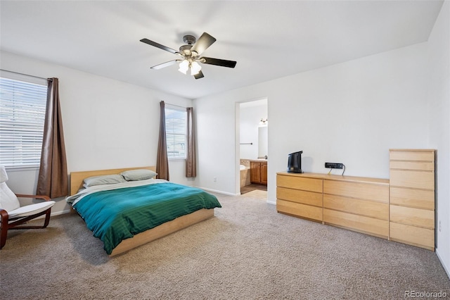 bedroom with light carpet, connected bathroom, a ceiling fan, and baseboards