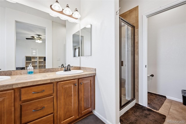 full bathroom featuring double vanity, a stall shower, ceiling fan, tile patterned flooring, and a sink