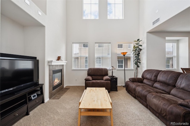 9374 Loggia St Unit D, Highlands Ranch, CO 80126 - living area featuring carpet, a high ceiling, a tiled fireplace, and baseboards