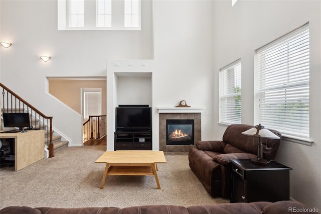 9374 Loggia St Unit D, Highlands Ranch, CO 80126 - living area with a towering ceiling, stairs, a tile fireplace, and carpet