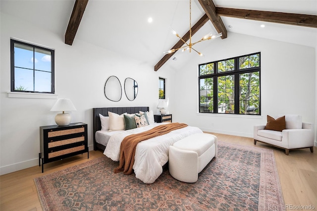 bedroom with light hardwood / wood-style floors, lofted ceiling with beams, and an inviting chandelier