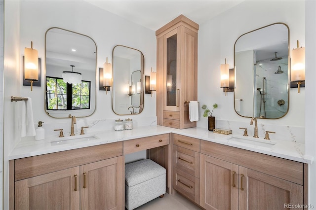 bathroom featuring a shower with door and vanity