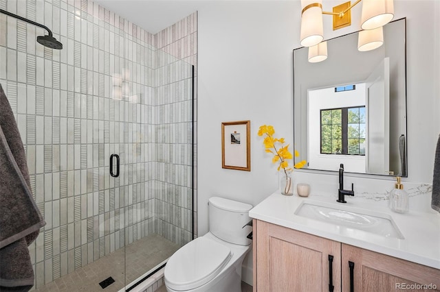 bathroom with vanity, a shower with shower door, and toilet