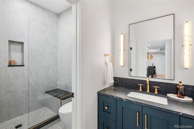 bathroom with tile patterned floors, vanity, a shower with shower door, and toilet