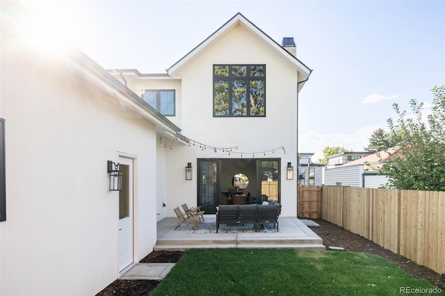 back of property with a lawn, an outdoor living space, and a patio