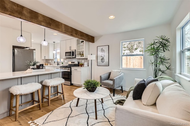 1120 Xenia St, Denver, CO 80220 - living room with beamed ceiling, recessed lighting, light wood-style flooring, and baseboards
