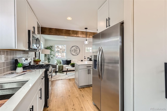 1120 Xenia St, Denver, CO 80220 - kitchen featuring stainless steel appliances, decorative backsplash, light wood-style floors, decorative light fixtures, and open floor plan