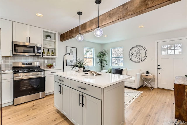 1120 Xenia St, Denver, CO 80220 - kitchen featuring light wood-style flooring, stainless steel appliances, decorative backsplash, light countertops, and beamed ceiling