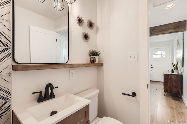 1120 Xenia St, Denver, CO 80220 - bathroom featuring vanity, toilet, and wood finished floors