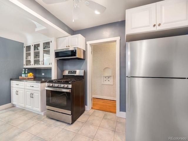1470 Utica St, Denver, CO 80204 - kitchen with appliances with stainless steel finishes, glass insert cabinets, white cabinets, light tile patterned floors, and ceiling fan