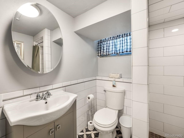 1470 Utica St, Denver, CO 80204 - bathroom featuring tile walls, vanity, and a wainscoted wall