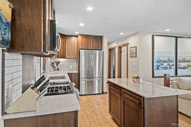 375 Castlewood Dr, Evergreen, CO 80439 - kitchen featuring stainless steel appliances, recessed lighting, decorative backsplash, light wood-style flooring, and a kitchen island