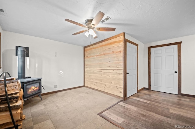 375 Castlewood Dr, Evergreen, CO 80439 - unfurnished bedroom with a wood stove, wood walls, and ceiling fan