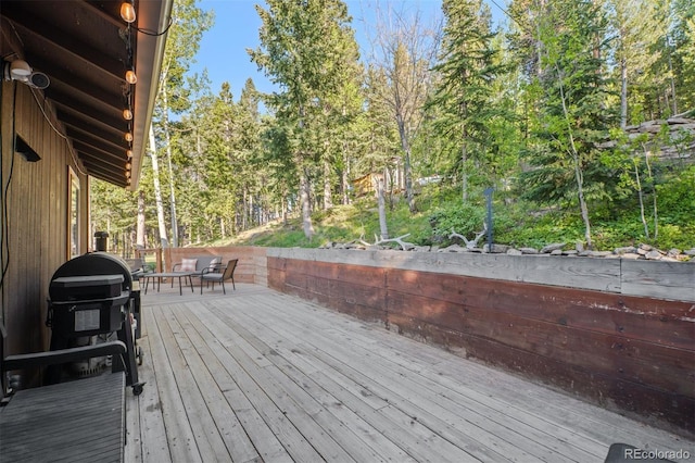 375 Castlewood Dr, Evergreen, CO 80439 - wooden terrace featuring view of wooded area and a grill