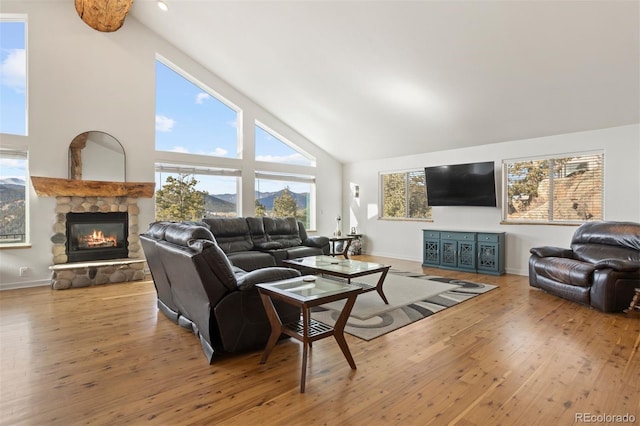 living room with hardwood / wood-style floors, beam ceiling, a fireplace, and high vaulted ceiling