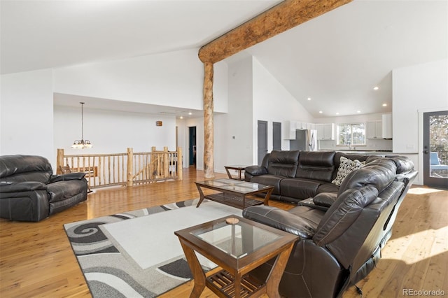 living room with light hardwood / wood-style flooring, high vaulted ceiling, and beamed ceiling