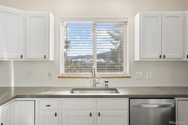 kitchen with stainless steel dishwasher, plenty of natural light, white cabinetry, and sink