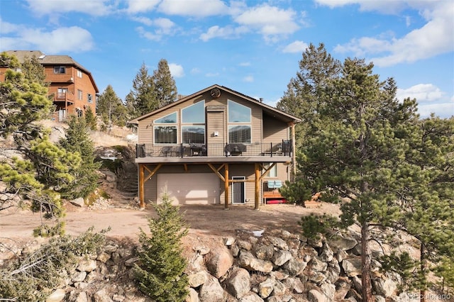 rear view of property with a garage and a wooden deck