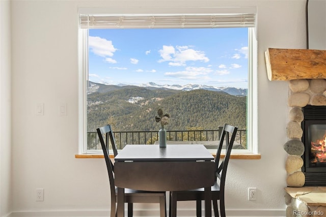 dining space with a mountain view, a fireplace, and plenty of natural light