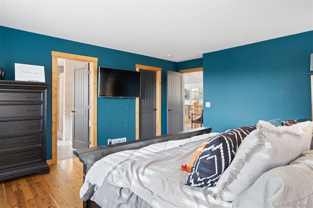 bedroom featuring light wood-type flooring and ensuite bathroom