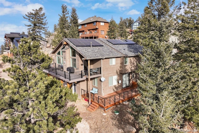 back of house with a balcony and solar panels