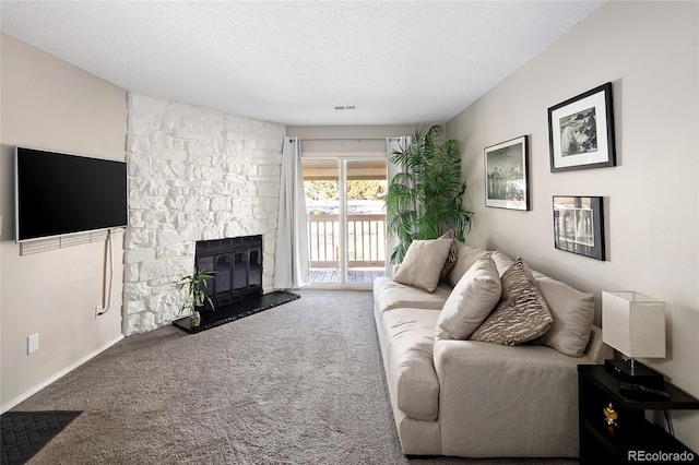 carpeted living room with a textured ceiling and a stone fireplace