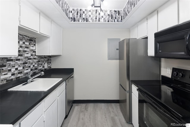 kitchen with black appliances, a sink, dark countertops, tasteful backsplash, and light wood-type flooring
