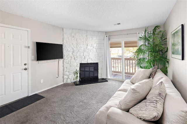 living room with carpet flooring, a stone fireplace, and a textured ceiling