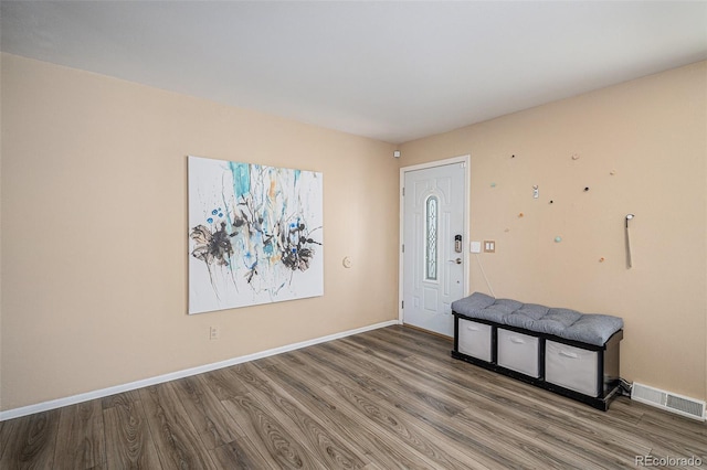 foyer with baseboards, wood finished floors, and visible vents
