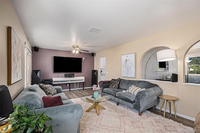 living room with visible vents, baseboards, ceiling fan, and wood finished floors