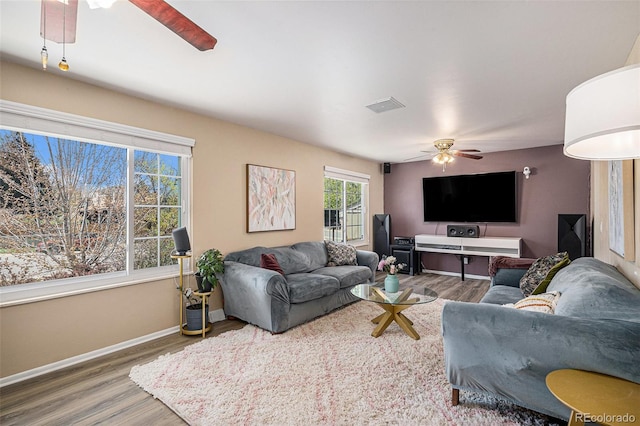 living room featuring baseboards, a ceiling fan, wood finished floors, and visible vents