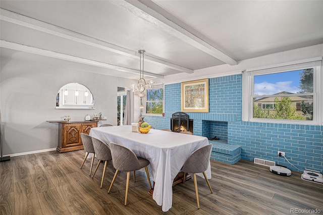 dining area with an inviting chandelier, beam ceiling, baseboards, visible vents, and dark wood-style floors