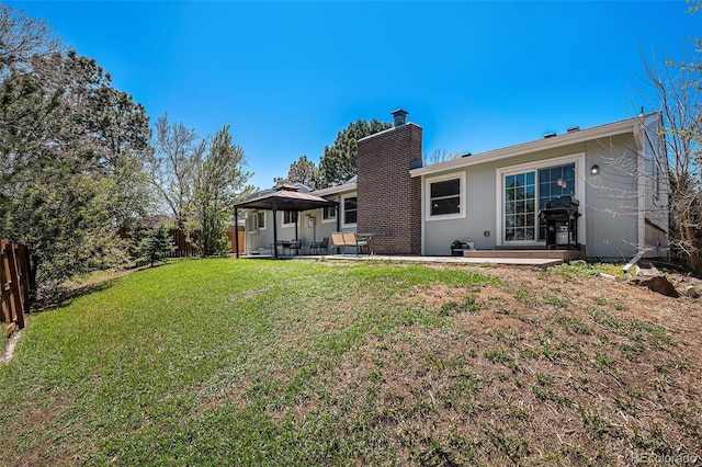 back of house with a gazebo, a chimney, a fenced backyard, and a patio area