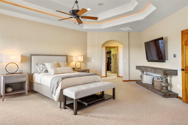 bedroom with crown molding, ceiling fan, a tray ceiling, and carpet