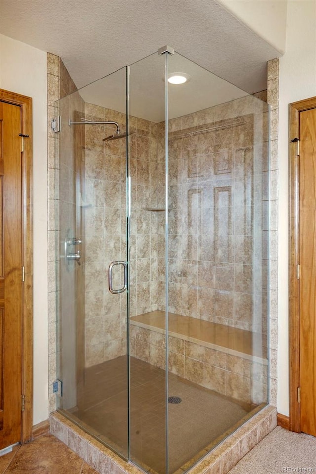 bathroom featuring an enclosed shower and a textured ceiling