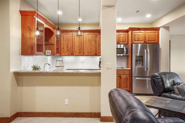 kitchen with a kitchen bar, sink, kitchen peninsula, pendant lighting, and stainless steel appliances