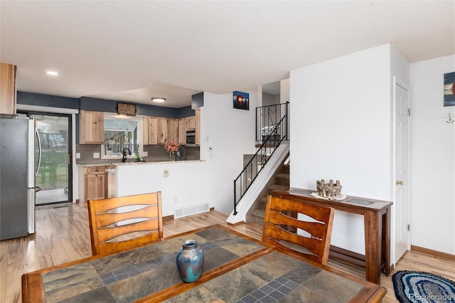 kitchen featuring appliances with stainless steel finishes, a sink, visible vents, and light wood-type flooring